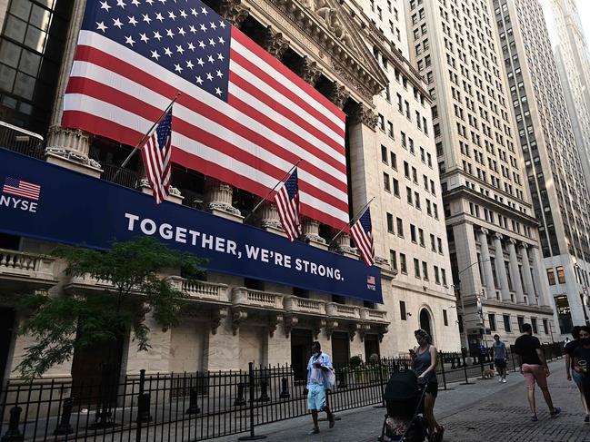 People walk outside the New York Stock Exchange (NYSE) on July 13, 2020 at Wall Street in New York City. - The Nasdaq tumbled July 13, 2020, ending a three-session streak of records on a weak day for US stocks amid fresh restrictions in California to address the coronavirus. (Photo by Johannes EISELE / AFP)