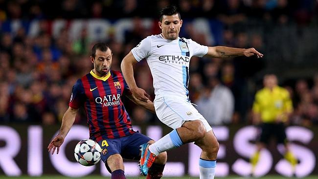 Sergio Aguero of Manchester City controls the ball as Javier Mascherano of Barcelona clos