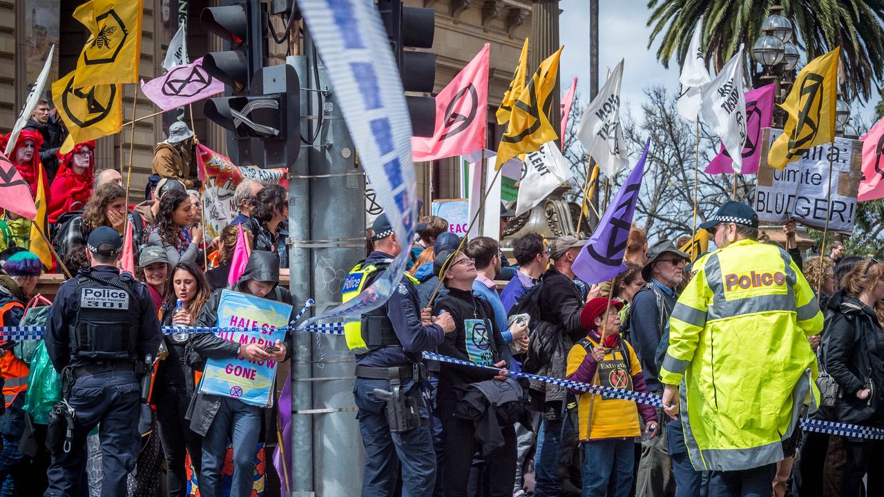 Extinction Rebellion protesters blockade the corner of Spring and Collins Streets in Melbourne before facing arrest. Picture: Jake Nowakowski