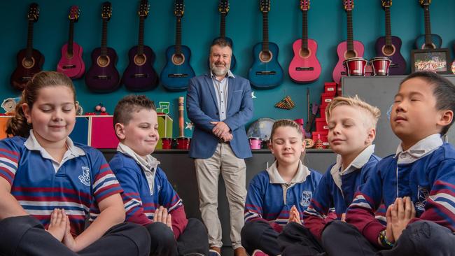 Students Rocci, Heath, Scarlett, Reilly and Owen practice mindfulness at St Christopher's School Airport West with principal Adrian Glasby. Picture: Jason Edwards