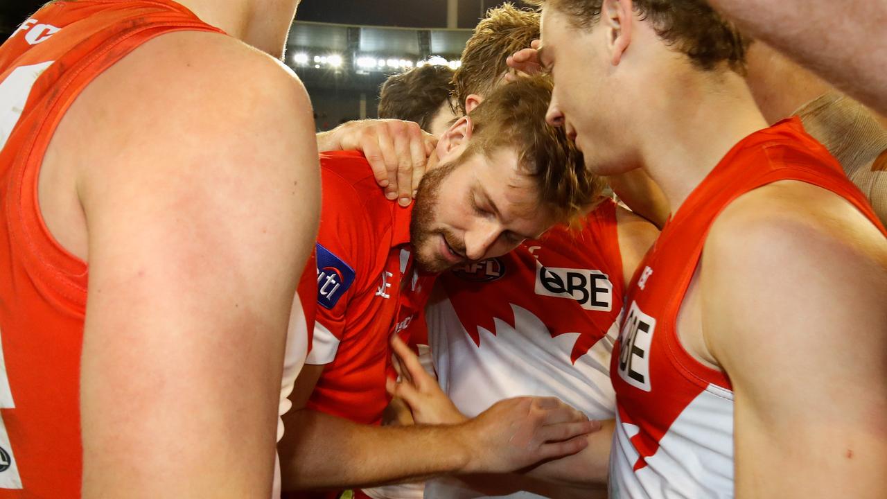 An injured Alex Johnson of the Swans is consoled by teammates. Photo: Adam Trafford/AFL Media/Getty Images