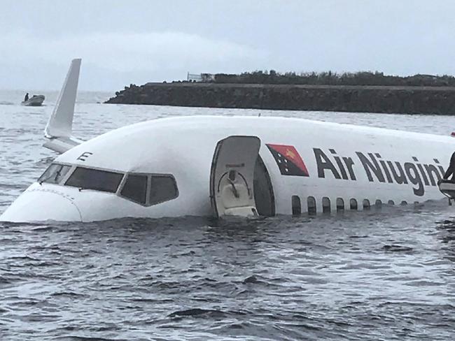 This photo taken by James Benito on September 28, 2018, shows locals approaching the crashed Air Niugini aircraft on the remote Island of Weno, in Micronesia. - An Air Niugini aircraft ditched into a lagoon after overshooting the runway on the remote island of Weno but there were no serious injuries, local media reports said. (Photo by JAMES BENITO / JAMES BENITO / AFP) / RESTRICTED TO EDITORIAL USE - MANDATORY CREDIT "AFP PHOTO / JAMES BENITO" - NO MARKETING NO ADVERTISING CAMPAIGNS - DISTRIBUTED AS A SERVICE TO CLIENTS == NO ARCHIVE