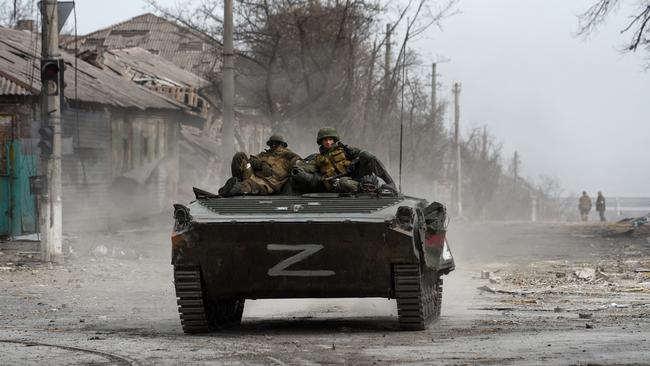 Russian troops sit atop an armoured vehicle in the streets of Mariupol. Picture: Reuters