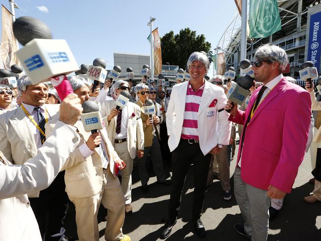 Glenn McGrath meeting 'The Richies' and donning a wig and coat as dozens of Richie Benaud impersonators arrive outside the stadium for the match. Picture: Tim Hunter.