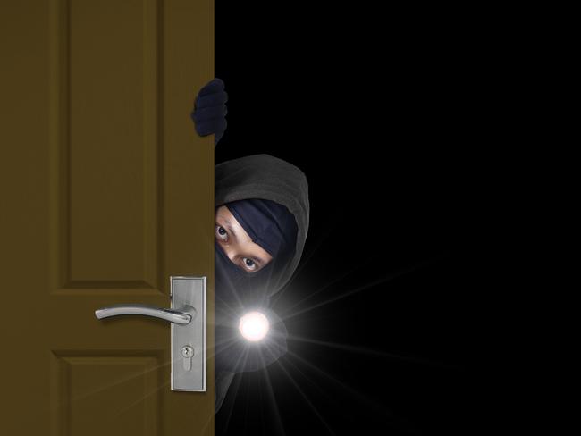 Burglar sneaking in a open house door during a break and enter past security locks and alarms, theft generic