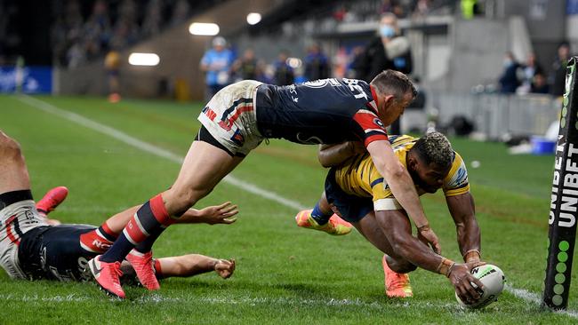 Maika Sivo of the Eels busts through a tackle by James Tedesco, left, and Brett Morris of the Roosters to score a try during the round-6 NRL match. Picture: Dan Himbrechts/AAP