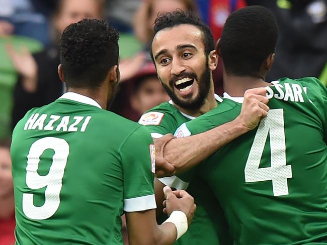 Mohammed Al Sahlawi of Saudi Arabia (C) celebrates after scoring a goal with Naif Hazazi (L) and Abdulla Aldossary (R) during the Group B Asian Cup football match between North Korea and Saudi Arabia in Melbourne on January 14, 2015. AFP PHOTO / MAL FAIRCLOUGH -- IMAGE RESTRICTED TO EDITORIAL USE - STRICTLY NO COMMERCIAL USE