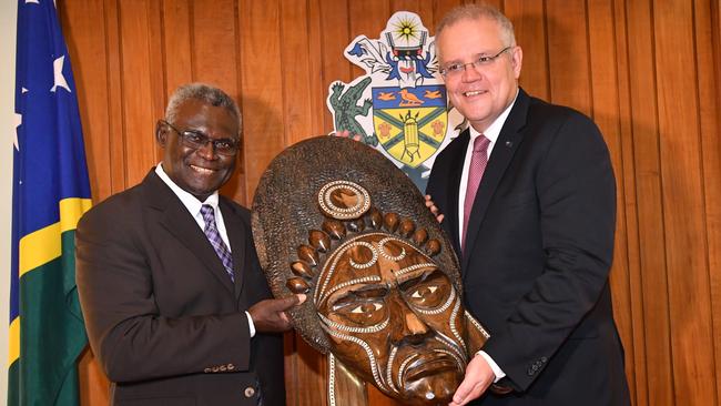 Solomon Islands Prime Minister Manasseh Sogavare (left) presents a traditional wood carving to Scott Morrison (right) in Honiara. Picture: AAP