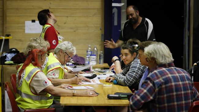 People sign up for the next evacuation by the navy at the Mallacoota Community Hall in Victoria. Picture: David Caird