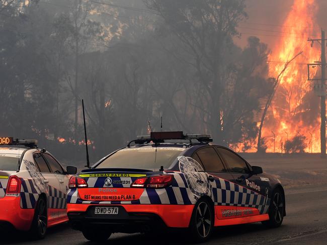 Rural Fire Service (RFS) crews work on a blaze threatening homes along the Old Hume Highway near the town of Tahmoor as the Green Wattle Creek Fire threatens a number of communities in the south west of Sydney, Thursday, December 19, 2019. Temperatures in the 40's and high north westerly winds under extreme fire conditions are fanning a a number of fires around Sydney(AAP Image/Dean Lewins) NO ARCHIVING