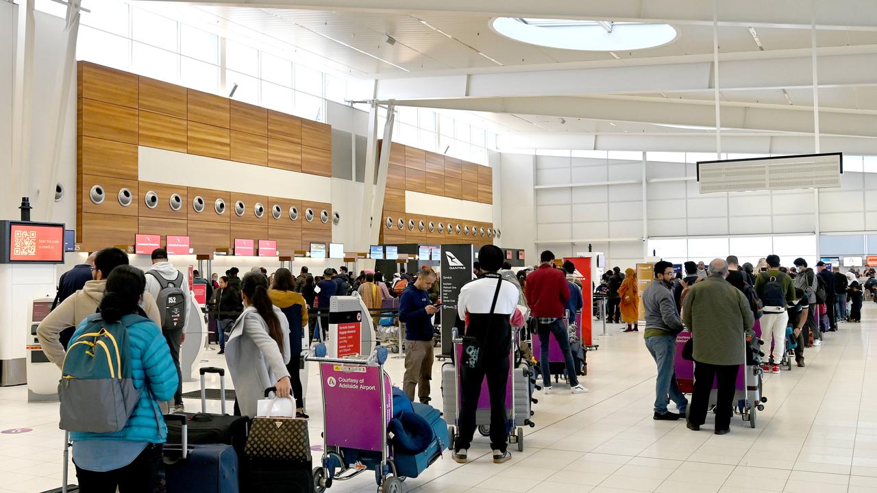 People line up at Adelaide airport where 15 flights were delayed and six cancelled due to fog. Picture: Naomi Jellicoe