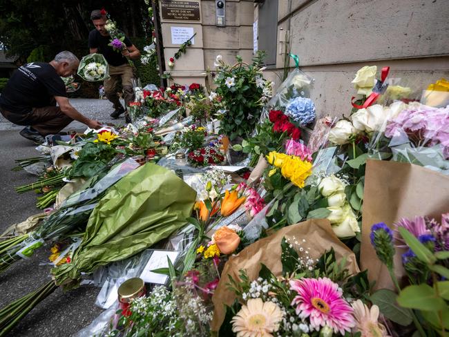 Groundskeepers move floral tributes into the grounds of Turner’s estate. Picture: AFP