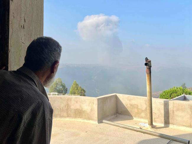 A man watches smoke billow after an Israeli airstrike in the southern Lebanese village of Qsair on August 25, 2024, amid escalations in the ongoing cross-border tensions as fighting continues between Israel and Hamas militants in the Gaza Strip. (Photo by AFP)