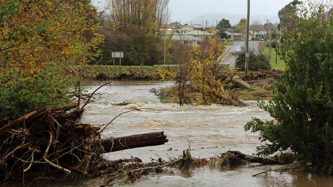 Water from flooded paddocks pours back into the Lachlan River near Hobart Rd at New Norfolk. Picture: DAMIAN BESTER