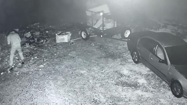 CCTV of two people cleaning up industrial rubbish dumped at an Upper Coomera property.