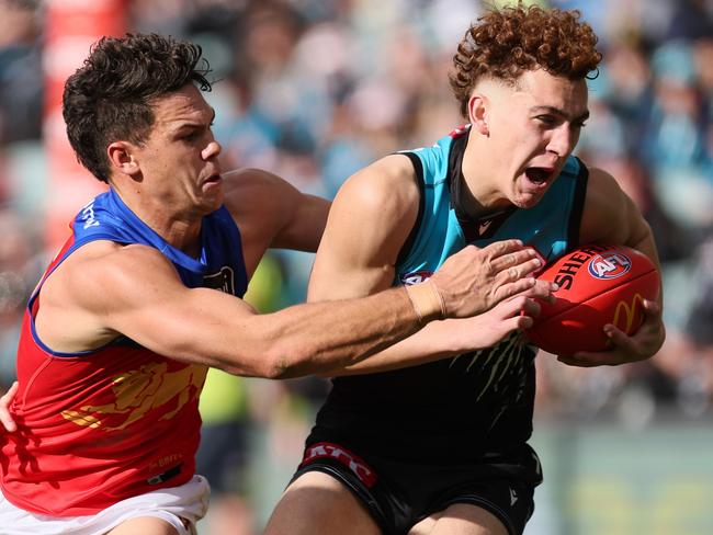 ADELAIDE, AUSTRALIA - JUNE 22: Logan Evans of the Power is tackled by Cam Rayner of the Lions during the 2024 AFL Round 15 match between the Port Adelaide Power and the Brisbane Lions at Adelaide Oval on June 22, 2024 in Adelaide, Australia. (Photo by James Elsby/AFL Photos via Getty Images)