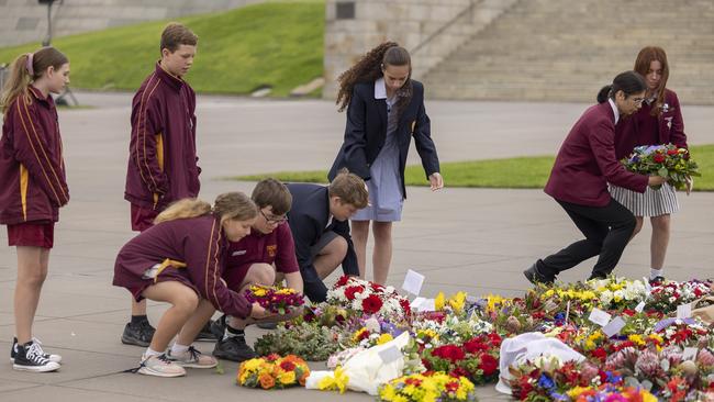 Students take turns laying wreaths at the Eternal Flame.