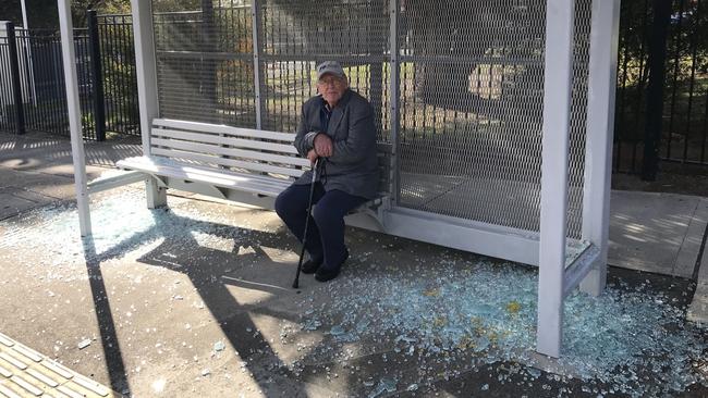 An elderly man sitting in the ruined bus shelter outside the RSL retirement village in Frankston.