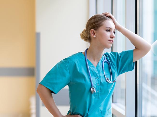 Tired female nurse in hospital corridor istock image