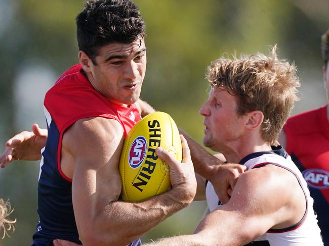 Christian Petracca of the Demons fends off Rory Sloane of the Crows during the AFL Marsh Community Series pre-season match between the Melbourne Demons and Adelaide Crows at Casey Fields in Melbourne, Saturday, February 22, 2020. (AAP Image/Michael Dodge) NO ARCHIVING, EDITORIAL USE ONLY