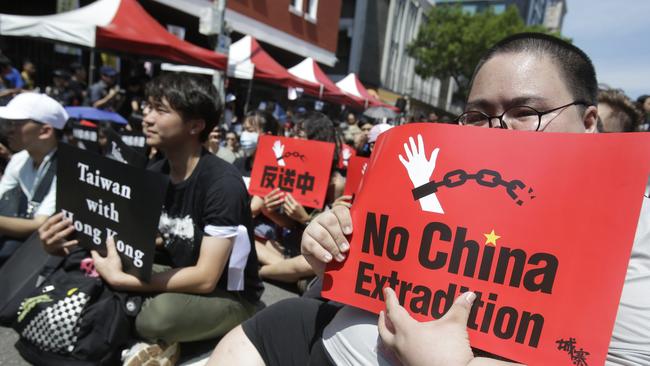 Hong Kong students and Taiwanese supporters hold slogans to oppose Hong Kong’s extradition law outside the Legislative Yuan in Taipei, Taiwan on Sunday. Picture: AP/Chiang Ying-ying