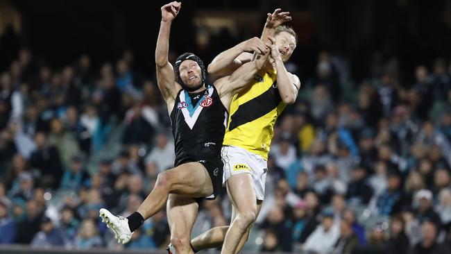 Brad Ebert runs back with the flight to courageously spoil Jack Riewoldt.