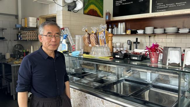 Cafe owner Henry Gao stands next to empty ice cream trays after he was forced to throw out most foods following the fire-induced power outage. Picture: Elizabeth Pike