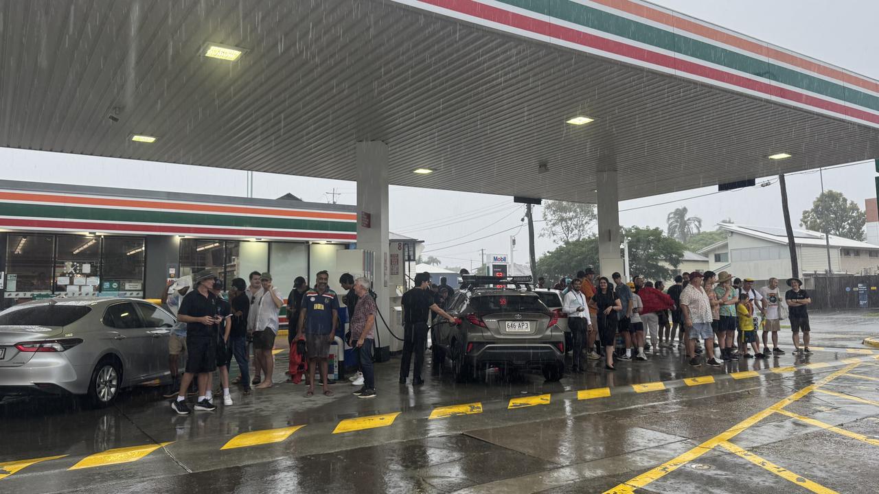 Cricket fans seeking shelter at a service station near the Gabba. Picture: Georgia Clelland