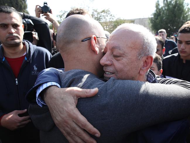 Saeed Maasarwe, the father of Aiia, hugs a mourner at her funeral. Picture: Ella Pellegrini