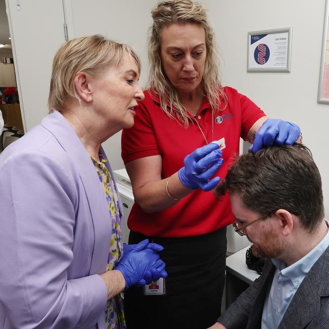 Ros Bates and a nurse with journalist Andrew Messenger who split his head open on his way to a media conference. Picture: Liam Kidston.