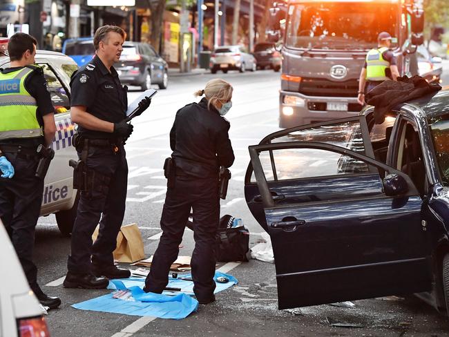 Police search a car on Bourke St after a dramatic arrest. Picture: Jason Edwards