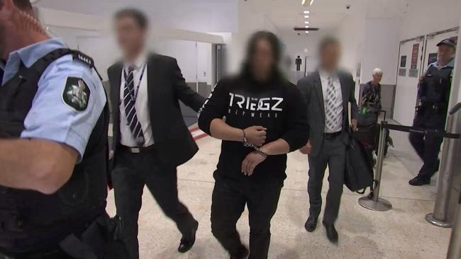 Police lead the arrested man through Sydney Airport.