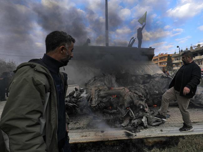 Syrian Kurds destroy the statue of Basel al-Assad, the late elder brother of Syria's President Bashar al-Assad as they celebrate the fall of capital Damascus to anti-government fighters. Picture: AFP