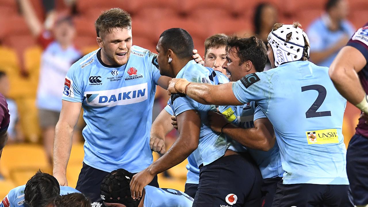 Kurtley Beale of the Waratahs celebrates with teammates after scoring a try.