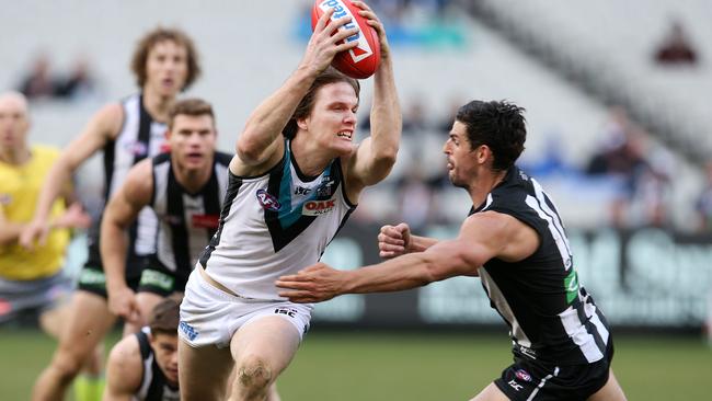 Jared Polec charges past Collingwood's Scott Pendlebury. Picture: Michael Klein