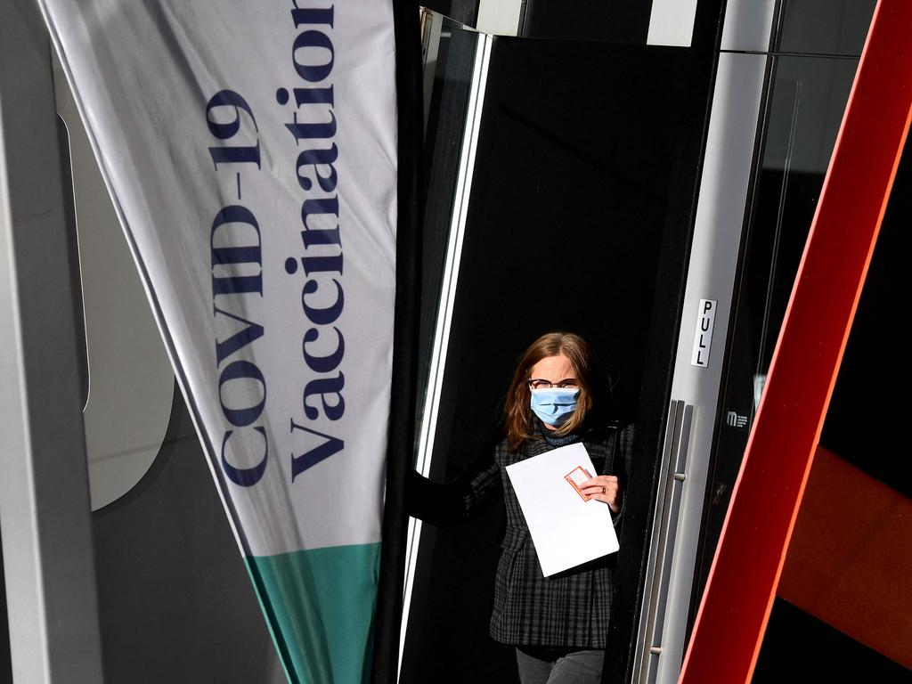 A woman emerges from a Covid-19 vaccination centre in Melbourne on May 24, 2021 as the city records four new locally acquired cases of Covid-19 in the community after 85 day free of the virus. (Photo by William WEST / AFP)