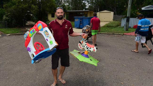 Flooding in Laura Court, Deeragun. Sean Koch helps to remove damaged goods from his mate's house, Daniel Hanran. Picture: Evan Morgan