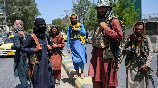 Taliban fighters stand guard along a street near the Zanbaq Square in Kabul on Monday. Picture: Kohsar / AFP