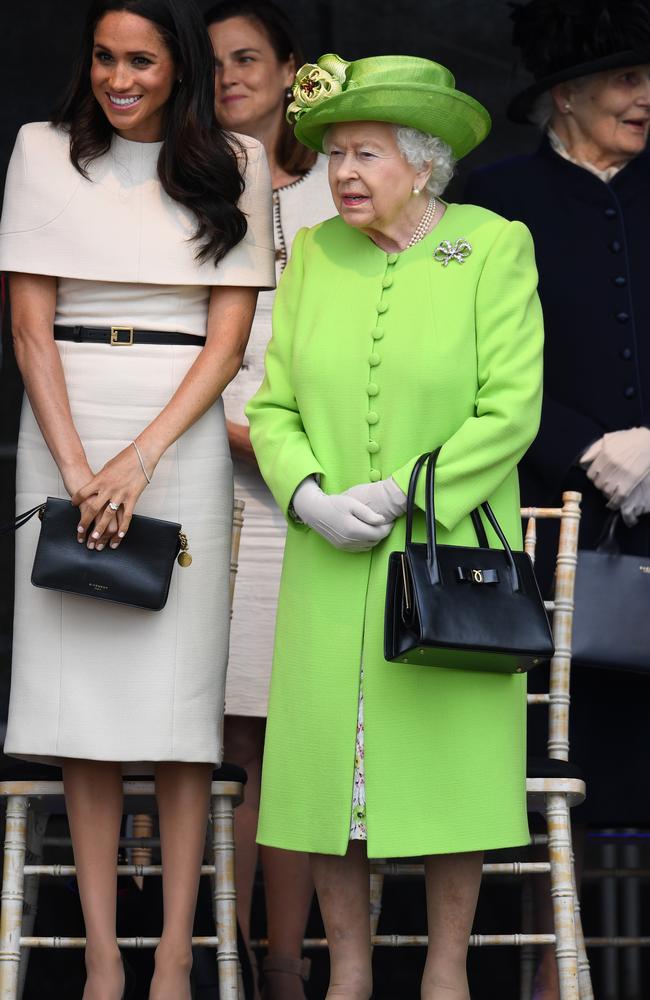 Queen Elizabeth II stands with Meghan, who wore her beige tights … again.