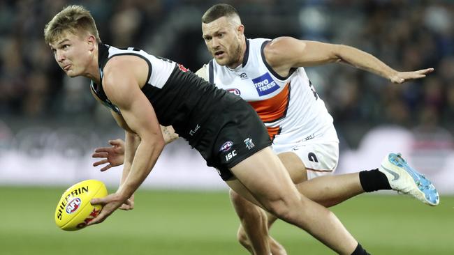 Port Adelaide Ollie Wines gets his handpass away from Giants Sam Reid. Picture SARAH REED