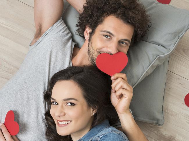 Happy Couple Holding Red Hearts THINKSTOCK IMAGE