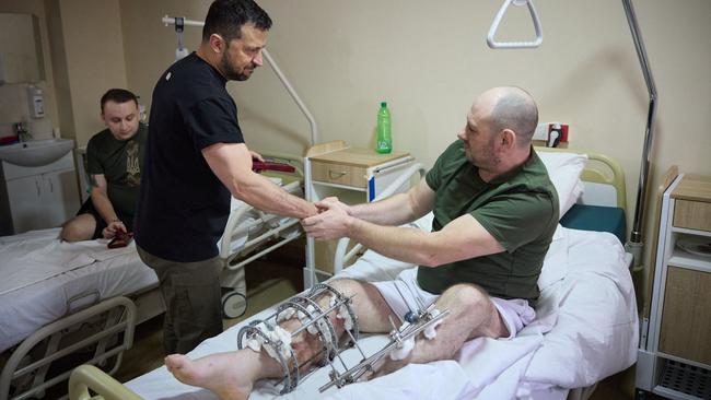 Ukrainian President Volodymyr Zelensky shakes hands with a wounded Ukrainian serviceman in a military hospital in western Ukraine. Picture: AFP