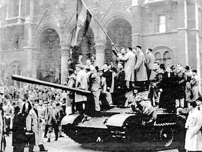 Hungarian rebels on tank wave the national flag at the main square in front of the House of Parliament in Budapest, 1956.