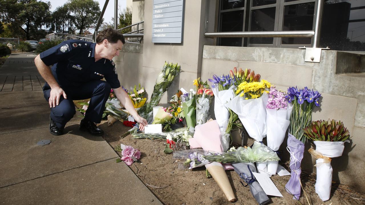 Victoria Police Deputy Commissioner Shane Patton adds to the floral tributes outside Boroondara Police Station in Kew. Picture: David Caird