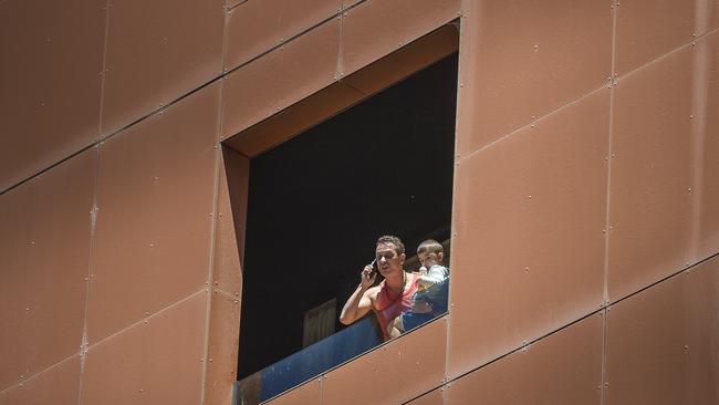 Bekin Jelaledin on his balcony extremely upset and holding his son Murt. Picture: NCA NewsWire / Roy VanDerVegt