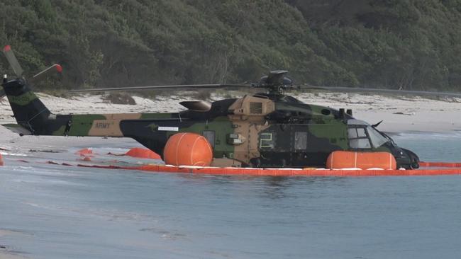 The MRH-90 Taipan helicopter is seen in shallow water on the beach after crashing off Jervis Bay. Picture: TNV