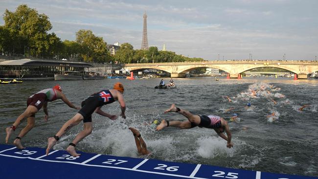 Triathlon athletes dive into the Seine River with the Eiffel Tower in the background during the men's 2023 World Triathlon Olympic Games test event, on August 18, 2023. The event was cancelled due to water pollution. Picture: Bertrand Guay / AFP