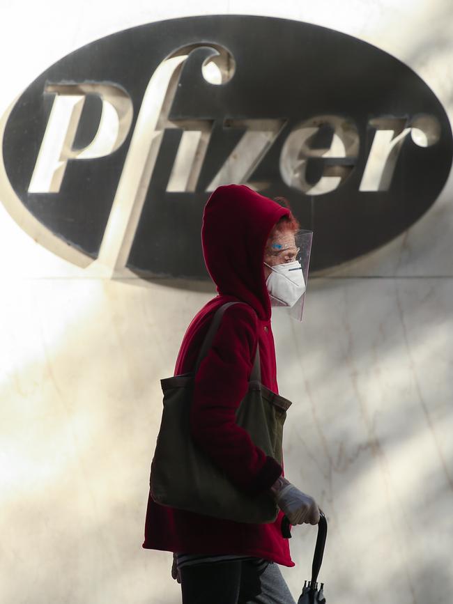 A woman wears a face mask as she walks by the Pfizer world headquarters in New York. Picture: AFP