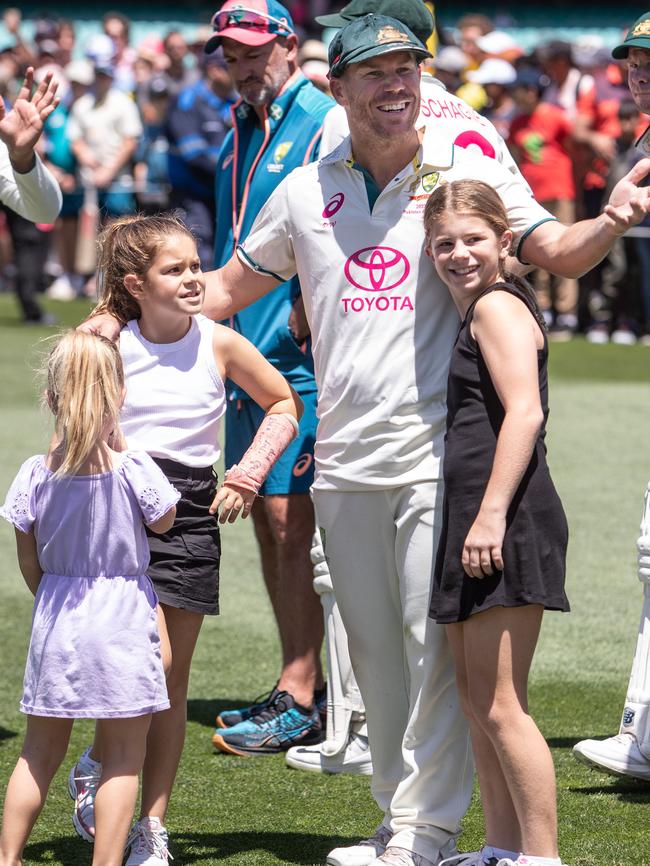 Warner with his daughters as he leaves the field. Picture: Julian Andrews