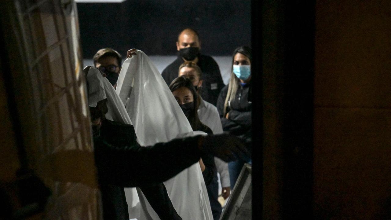 Member's of the Technical Investigation Team transport Foo Fighters' drummer Taylor Hawkins’ body from a hotel in Bogota.